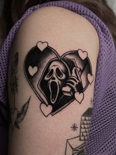 a woman's arm with a tattoo on it that has a heart and a skeleton in the middle