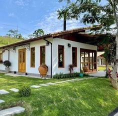 a white house sitting on top of a lush green field