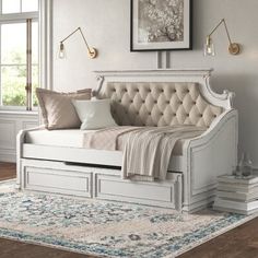 a white daybed sitting on top of a wooden floor