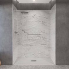 an empty bathroom with white marble walls and floor, along with a shower head in the corner