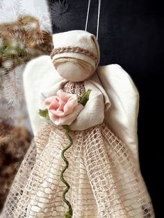 an angel ornament with a pink rose on it