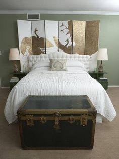 a bedroom with a large bed and paintings on the wall next to two nightstands