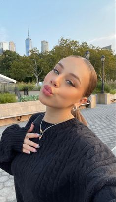 a woman is taking a selfie with her cell phone in front of her face