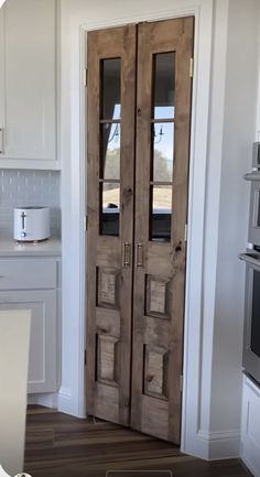 two wooden doors in a kitchen with white cabinets