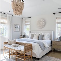 a bedroom with a large bed and chandelier hanging from it's ceiling