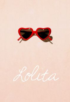 a pair of heart shaped sunglasses sitting on top of a pink surface with the word solita written below it