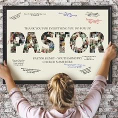 a woman holding up a poster with the word pastor written on it in front of her