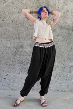 Cupro Harem Pants in black are the new member of Odana's Sustainable Outfits. Ethically handmade from Cupro fabric, these pants breathe extremely well. With silky soft feel, they are luxuriously comfortable, which makes them an impeccable choice for warm months. Cupro, also known as Vegan Silk fabric is made from cotton linters. We use Oeko-Tex-certified, bio-degradable Cupro produced with a zero-waste policy. Breath Harem Pants are available in a variety of size choices from XS to big and tall. Indulge yourself with these drop crotch pants, enjoy the soft silky touch, the gentle flowy fit, and all the compliments you'll get! These pants would make a great couple with sandals, sneakers, our crop tops, and Shaman top. This one would be a luxurious addition to your sustainable wardrobe. This Bohemian Style Black Straight Pants, Bohemian Black Straight Pants, Black Bohemian Straight Pants, Bohemian Style Baggy Straight Pants, Baggy Bohemian Straight Pants, Bohemian Baggy Straight Pants, Casual High-waisted Festival Pants, Casual High-waisted Pants For Festival, Festival Straight Pants With Elastic Waistband