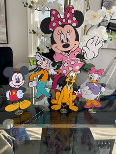 a glass table topped with mickey mouse cut outs