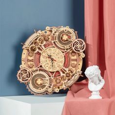 an ornate clock sitting on top of a table next to a busturine and curtain