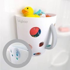 there is a cup with some rubber ducks in it and two cups on the wall