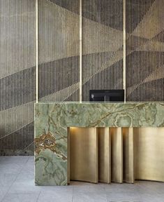 a large marble counter in front of a wall with gold bars on it and a tv mounted to the side