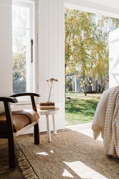 a bedroom with a bed, chair and table in front of a sliding glass door