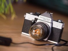 an old camera sitting on top of a wooden table