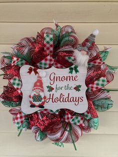 a christmas wreath with gnomes for the holidays written on it and santa's hat