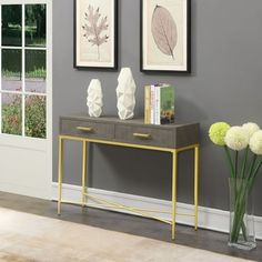 two white vases sitting on top of a wooden table next to a gray wall