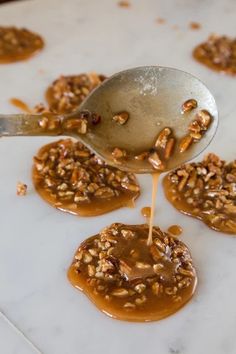 spoon drizzling caramel sauce on top of pecan cookies with walnuts