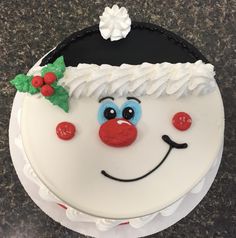 a cake decorated to look like a clown's face with holly leaves on top