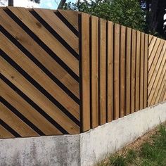 a wooden fence next to a white wall