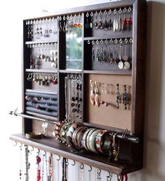 a wall mounted jewelry rack with lots of necklaces and earrings hanging on it's sides