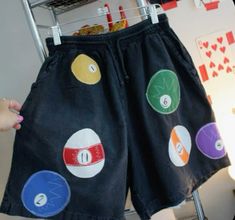 a pair of shorts with buttons on them hanging from a rack in front of a wall