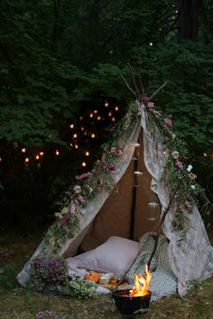 a teepee tent is lit up with fairy lights