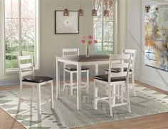 a dining room table with four chairs and a rug