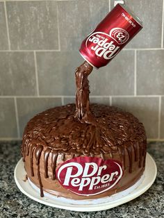 a chocolate cake with dr pepper on top and a can of soda being poured into it