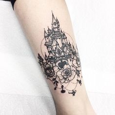 a woman's leg with a black and white castle tattoo on her left arm