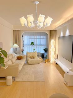 a living room filled with furniture and a flat screen tv on top of a wooden floor