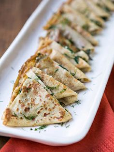 a white plate topped with quesadillas on top of a red napkin