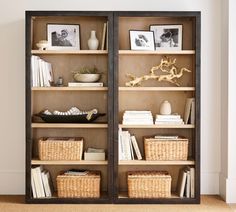 two open bookcases with baskets and pictures on them