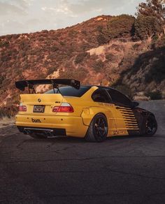 a yellow sports car parked in front of a mountain