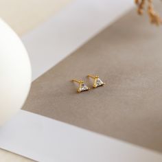 T R I X I E ∙ T R I A N G L E ∙ E A R R I N G S If you're looking for elegance and opulence, our Trixie Diamond Studs are the perfect medium. With a clean-cut triangle shaped diamond, the simplicity of these earrings make for a modern classic jewelry piece that never goes out of style. * Material: High Quality Solid 925 Sterling Silver * Finish: Sterling Silver ∙ 18K Gold * Featuring ~5mm Genuine CZ Diamond stud earrings. * Sold as a pair H O W ∙ T O ∙ O R D E R * Select your finish in the drop Triangle Diamond Earrings, Pave Heart Necklace, Classic Jewelry Pieces, Beautiful Stud Earrings, Triangle Diamond, Heart Locket Necklace, Triangle Studs, Custom Earrings, Diamond Stud Earrings