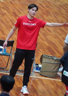 a young man standing on top of a basketball court