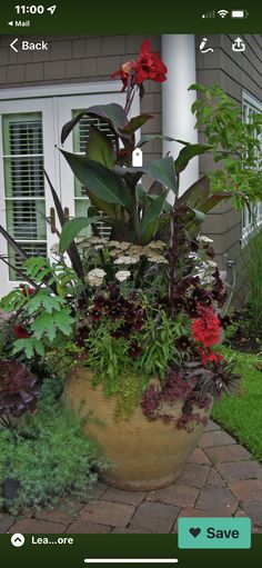 a planter filled with lots of flowers next to a house