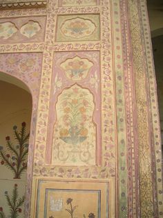 an intricately decorated wall with paintings and flowers