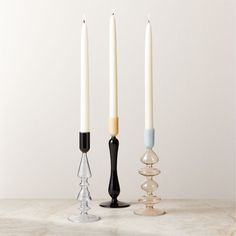 three candles sitting on top of a table next to each other with one candle in the middle