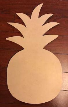 a paper cut out of a pineapple sitting on top of a wooden floor