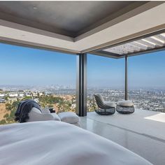 a bedroom with a large window overlooking the city