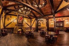 the inside of a restaurant with tables, chairs and a fire place in the center