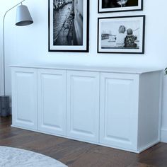 a living room with white walls and pictures on the wall