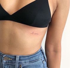 a woman's stomach with the word love tattooed on her left side ribcage