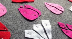 several pieces of felt sitting on top of a gray floor next to scissors and pins