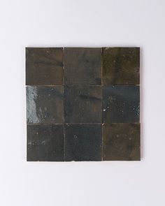 a black and brown square shaped tile on a white wall