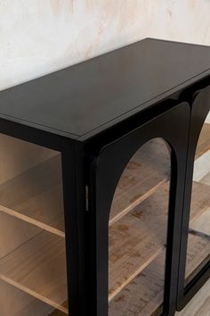 a black cabinet with glass doors and shelves