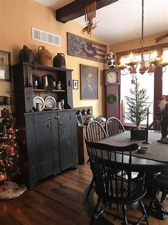 a dining room table and chairs with christmas decorations on the wall in front of it