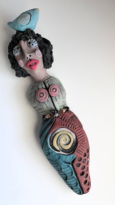 a ceramic sculpture of a woman holding a bird on her head