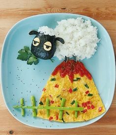 a plate with food on it and an animal made out of eggs, rice, and veggies