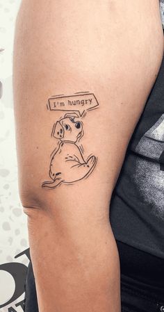 a man with a tattoo on his arm that says i'm hungry and a dog